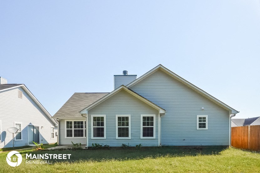 a blue house with a wooden fence in front of it