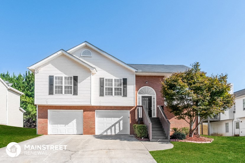 a white house with two garages and a driveway