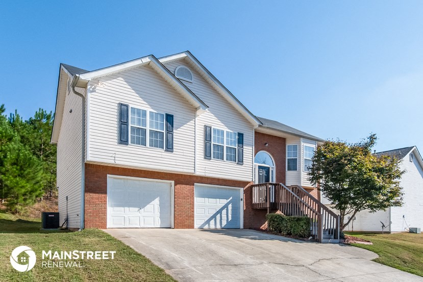 a white house with two garages and a driveway