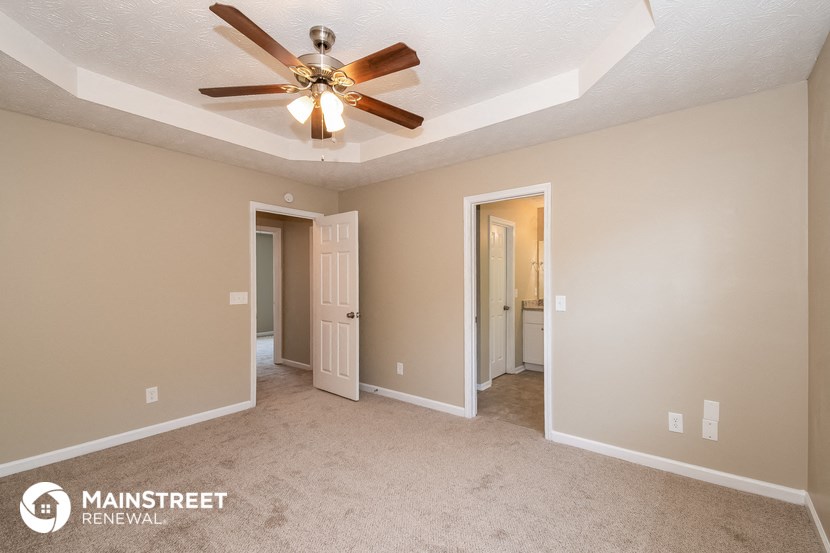 the master bedroom has a ceiling fan and carpeted flooring