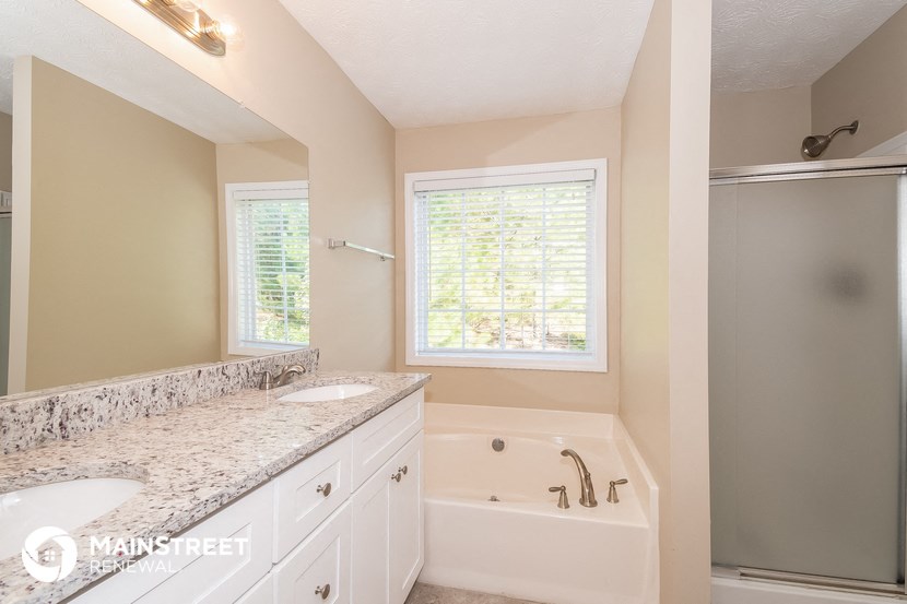 a bathroom with a tub and a sink and a mirror
