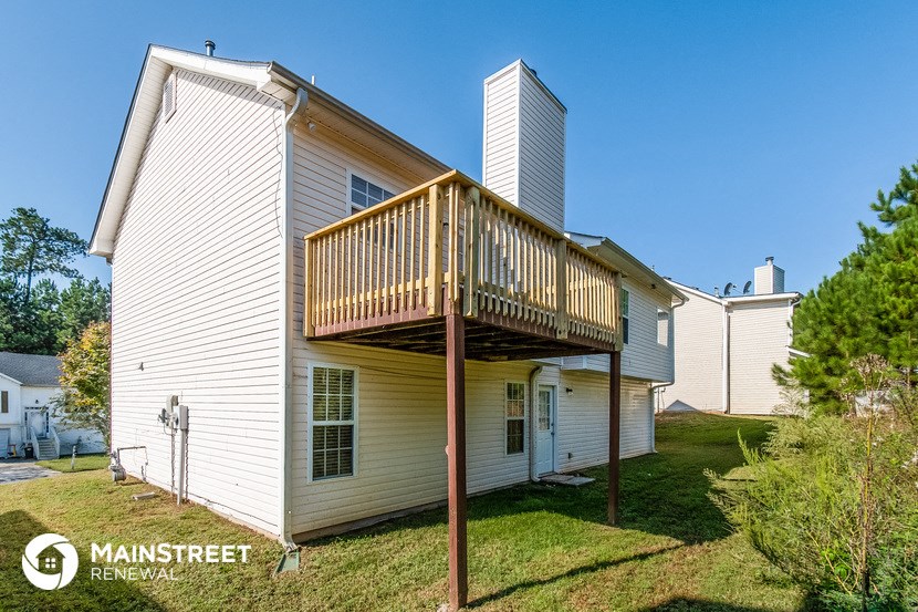 the view of the back of a house with a deck on top of it
