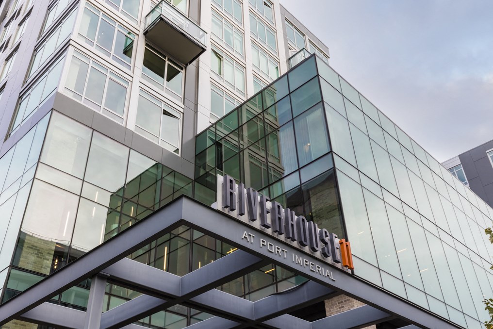 the front of a building with a glass facade and a sign on top of it