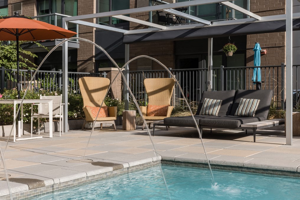 a swimming pool with two chairs and a water fountain