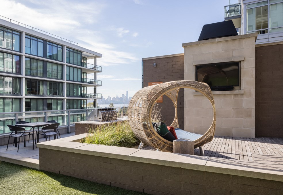 a person sitting in a rattan chair on a roof terrace