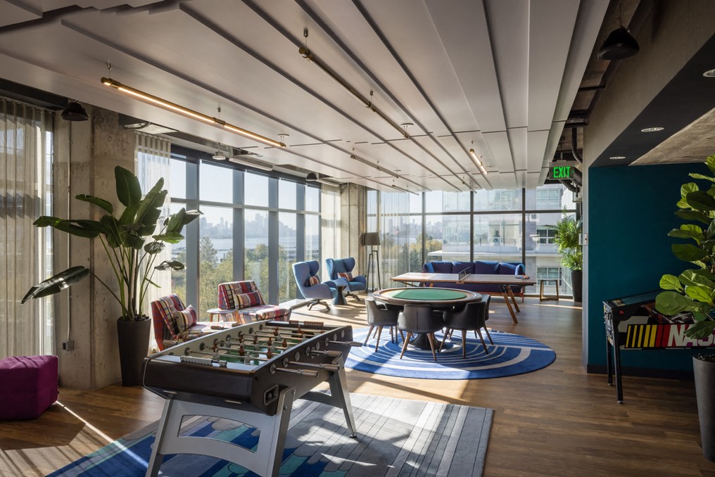 a game room with a foosball table and chairs and a large window