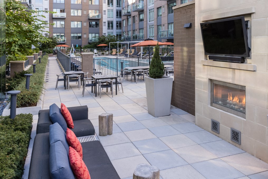 a patio with couches and tables and a fireplace