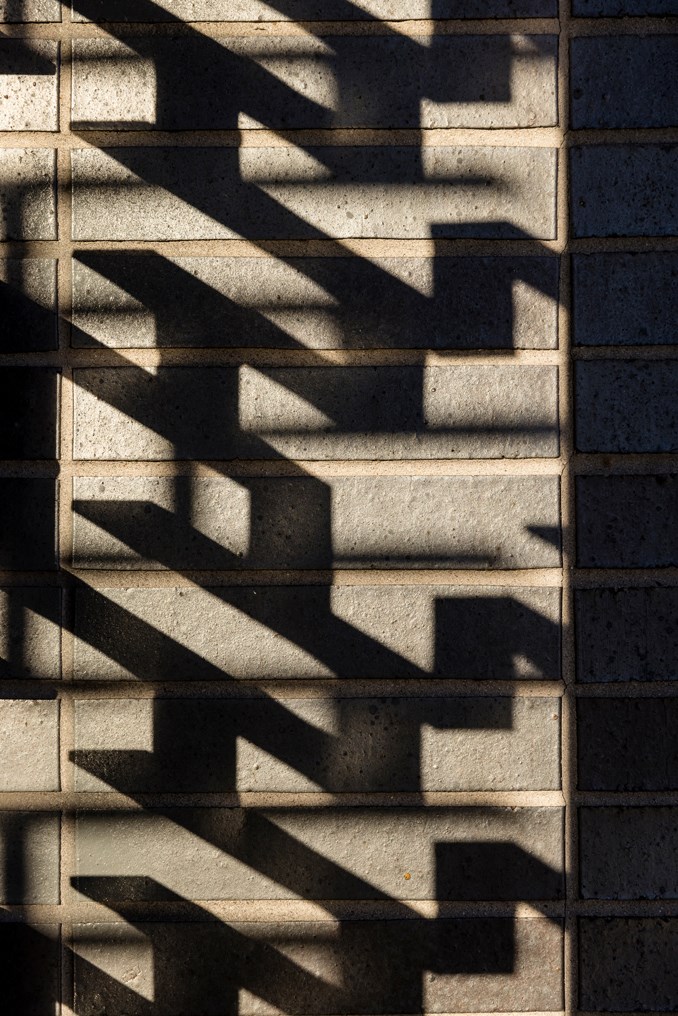 shadows on a brick wall with a shadow of a window