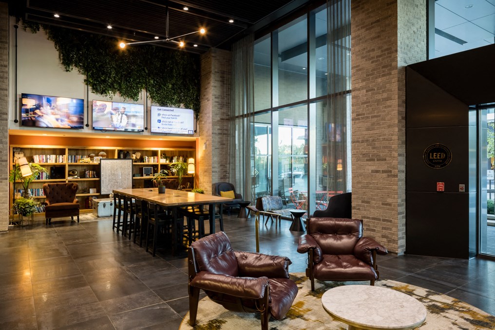 the lobby of a restaurant with leather chairs and a table
