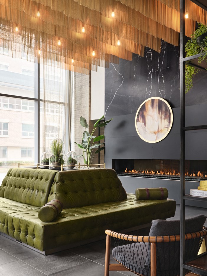 a living room with a green couch and a fireplace