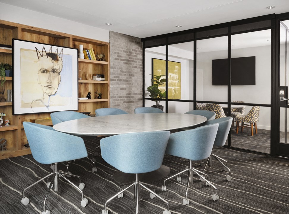 a conference room with a round table and blue chairs