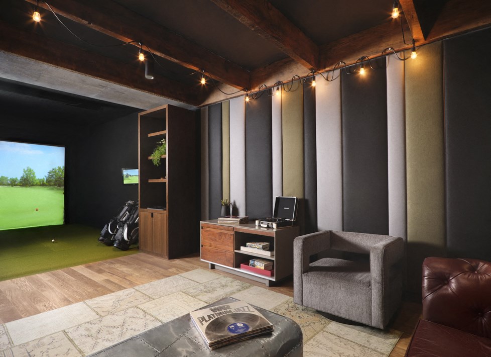 a living room with a tv and a golf simulator