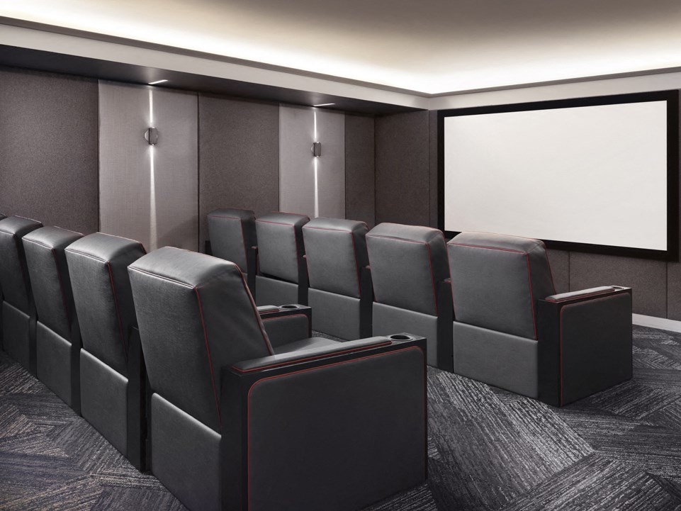 a theater room with leather seats and a projector screen