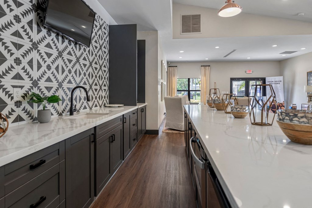 a large kitchen with white counter tops and black and white tiles