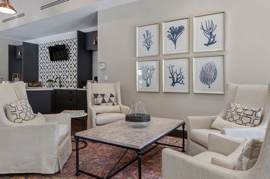 a living room with white furniture and pictures on the wall