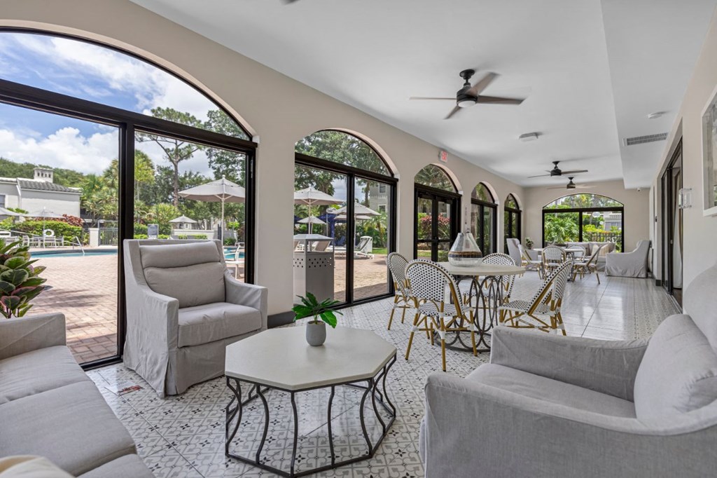a living room with couches and tables and large windows