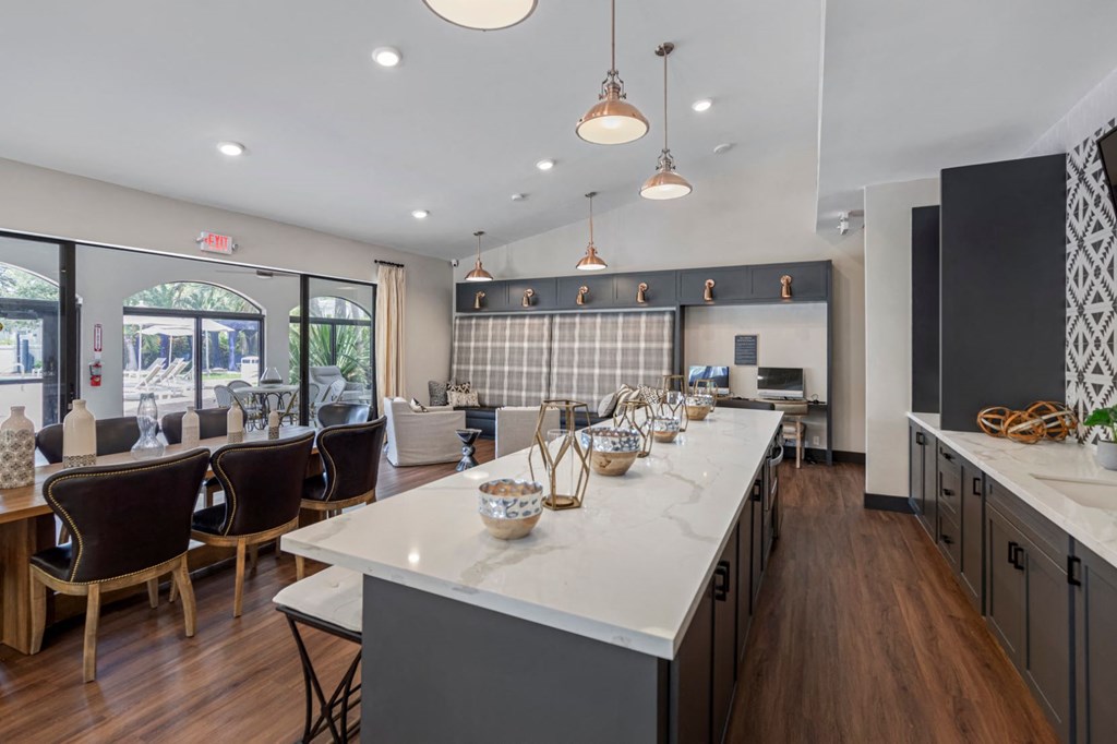 a kitchen with a long counter and a dining room with chairs
