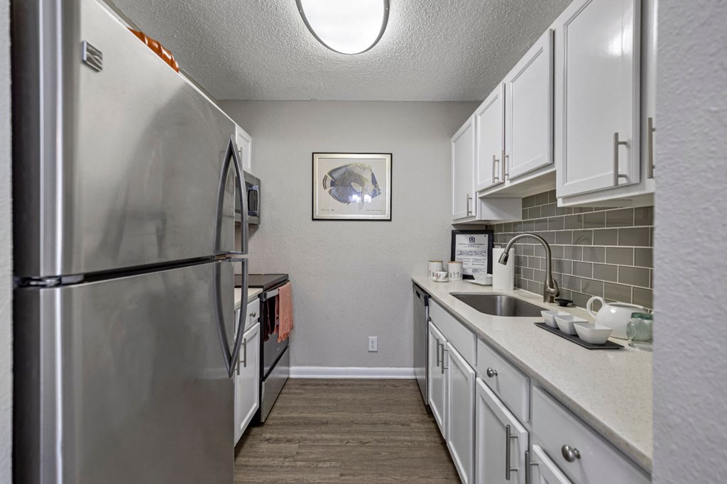 a kitchen with stainless steel appliances and white cabinets