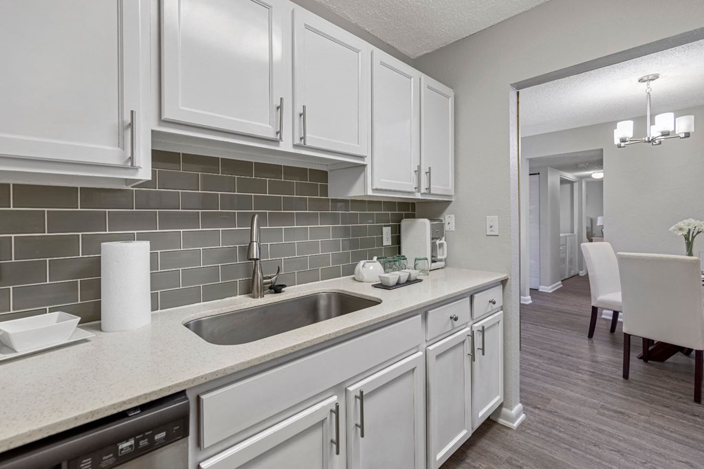 a kitchen with white cabinets and a sink