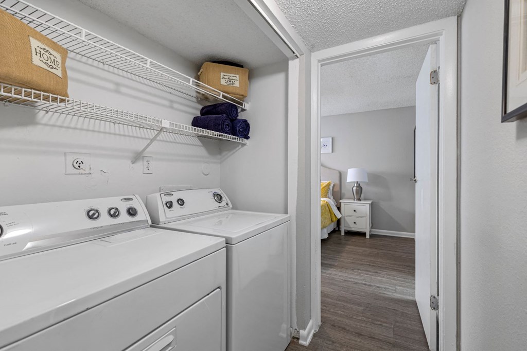 a white washer and dryer in a room with a bedroom