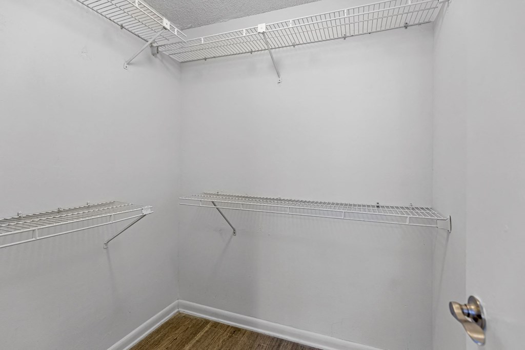 an empty room with white walls and two shelves on the wall