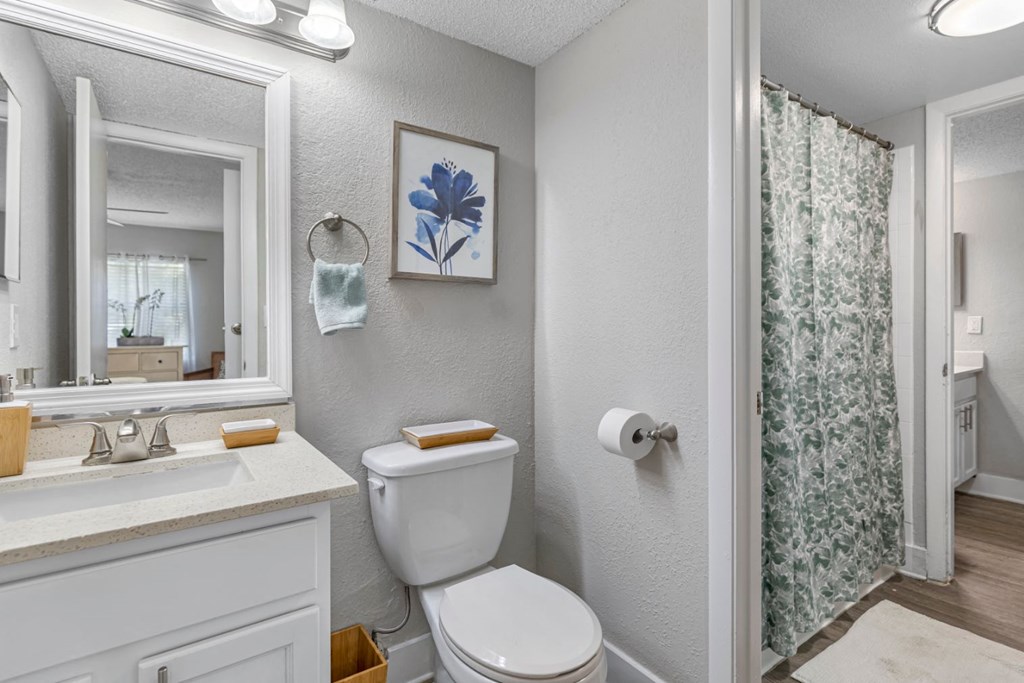 a white bathroom with a shower and a toilet