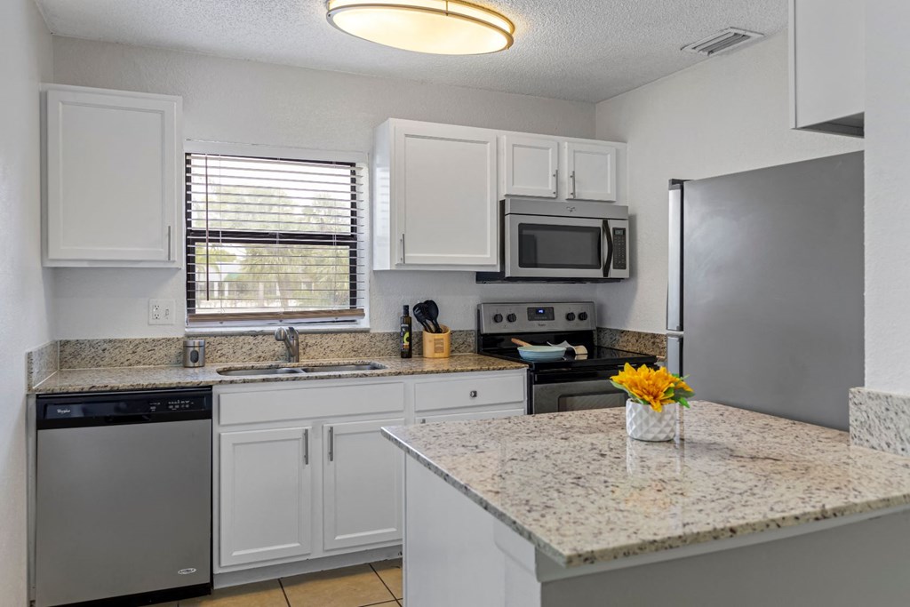 a kitchen with granite counter tops and stainless steel appliances