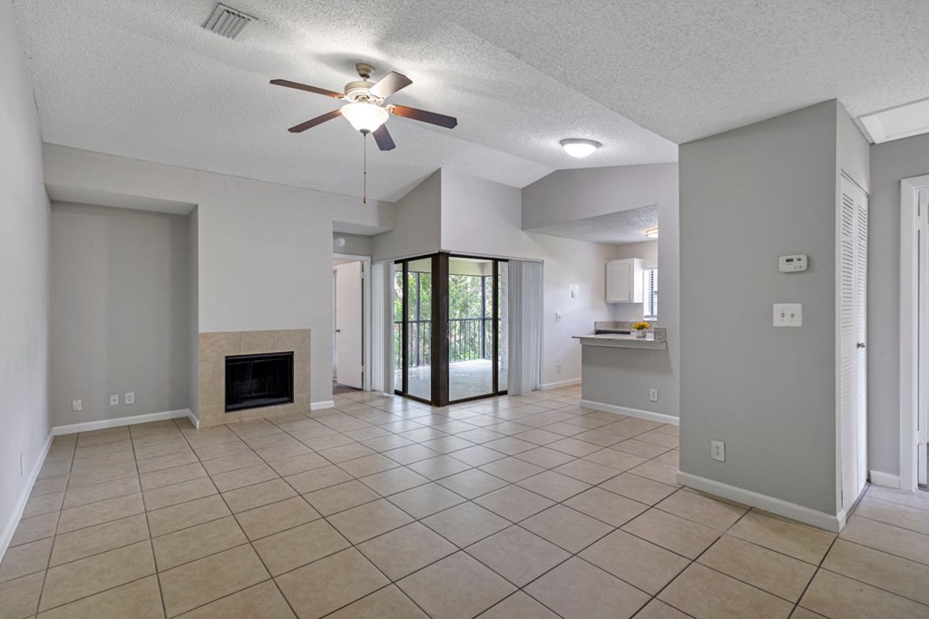a large living room with a fireplace and a ceiling fan