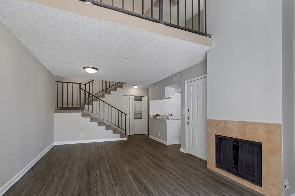 a living room with a fireplace and a staircase