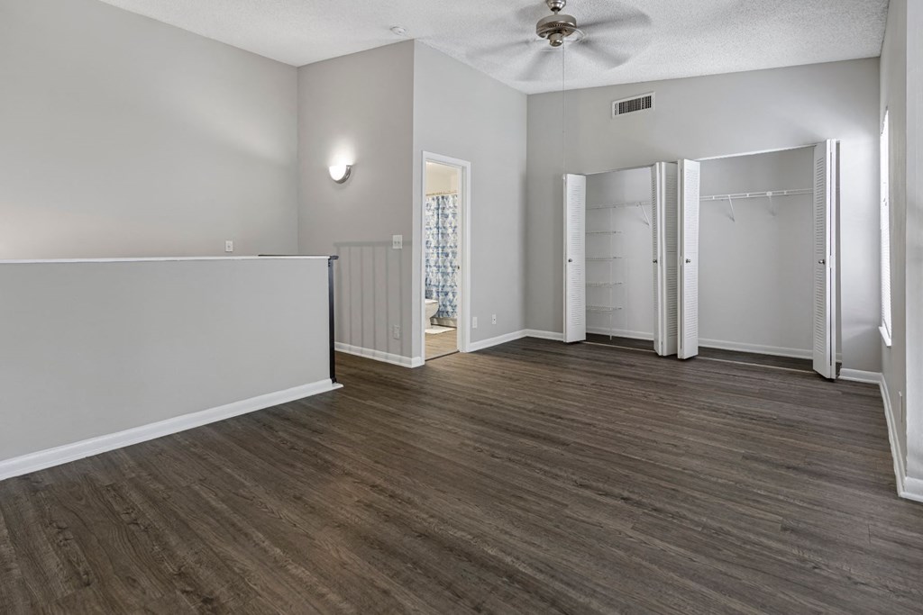 an empty living room with white walls and a ceiling fan