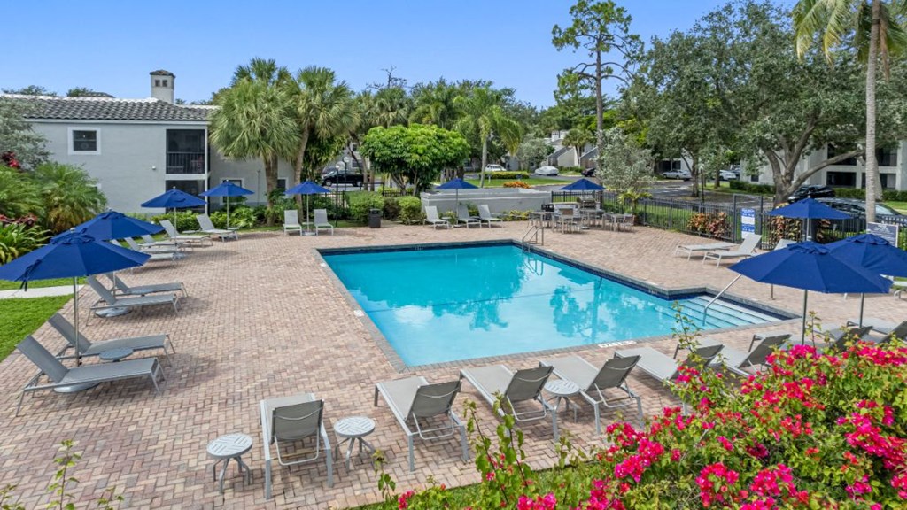 a swimming pool with umbrellas and chairs around it