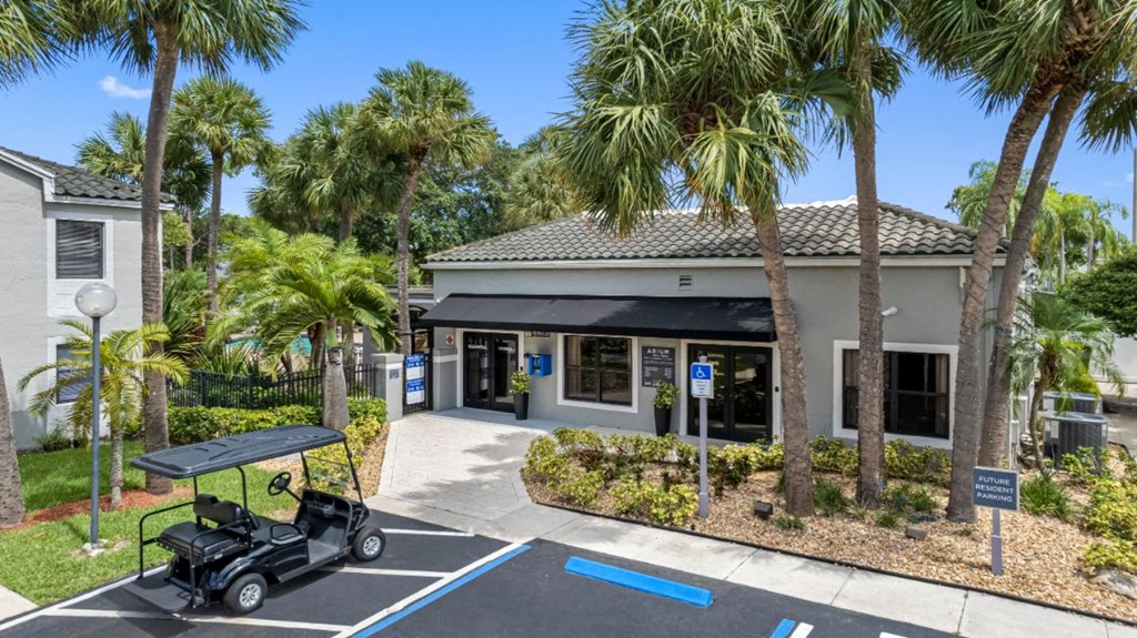 a golf cart parked in front of a building with palm trees