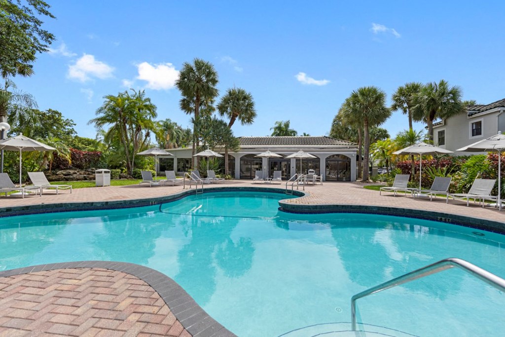 a swimming pool with palm trees and a house in the background