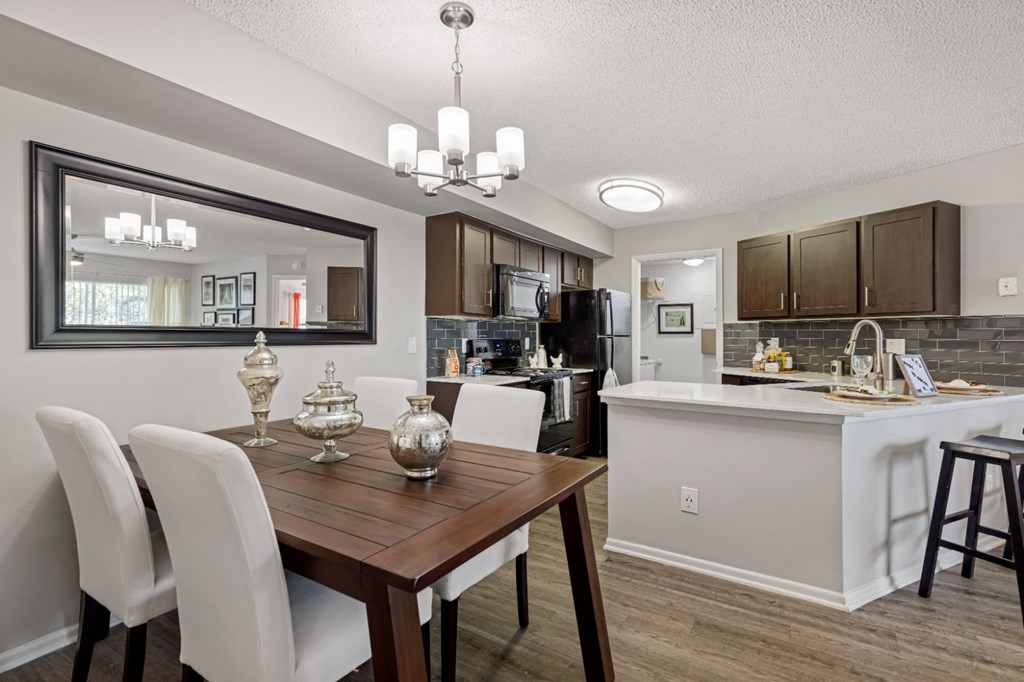 a dining room and kitchen with a table and chairs
