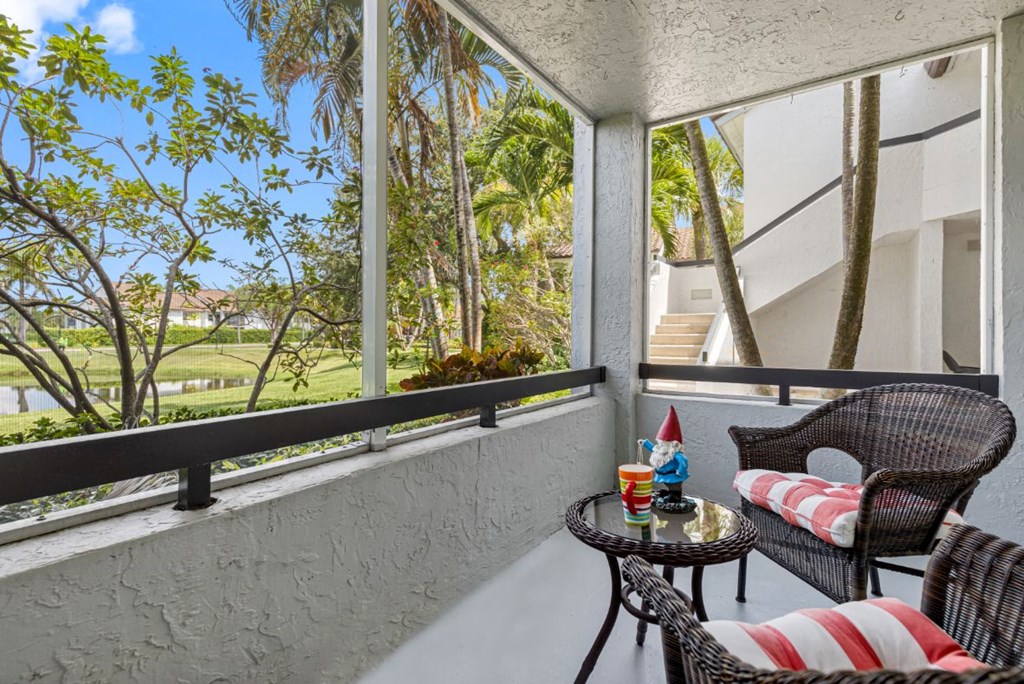 a patio with two chairs and a table on a balcony