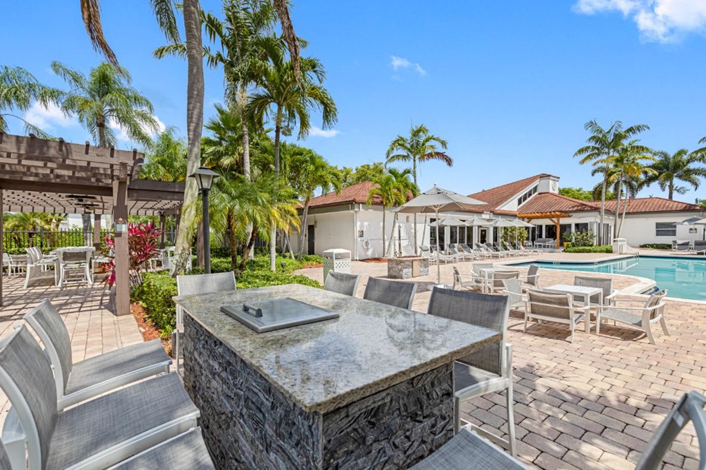 a patio with tables and chairs and a swimming pool