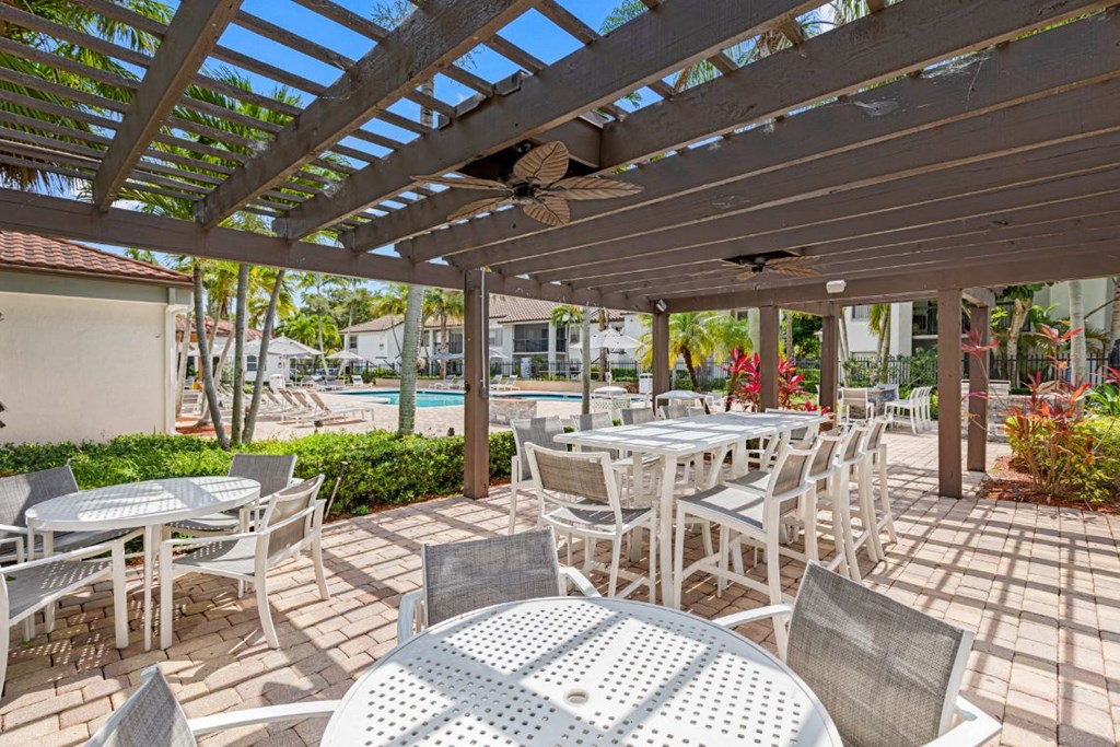 a patio with tables and chairs and a pergola