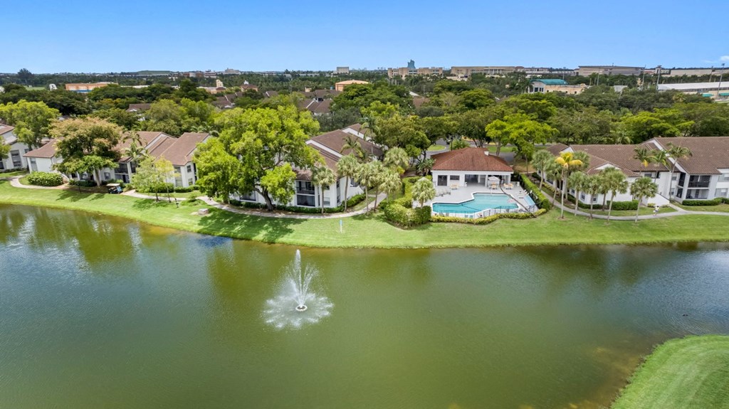 a mansion with a pool and a fountain in the middle of a lake