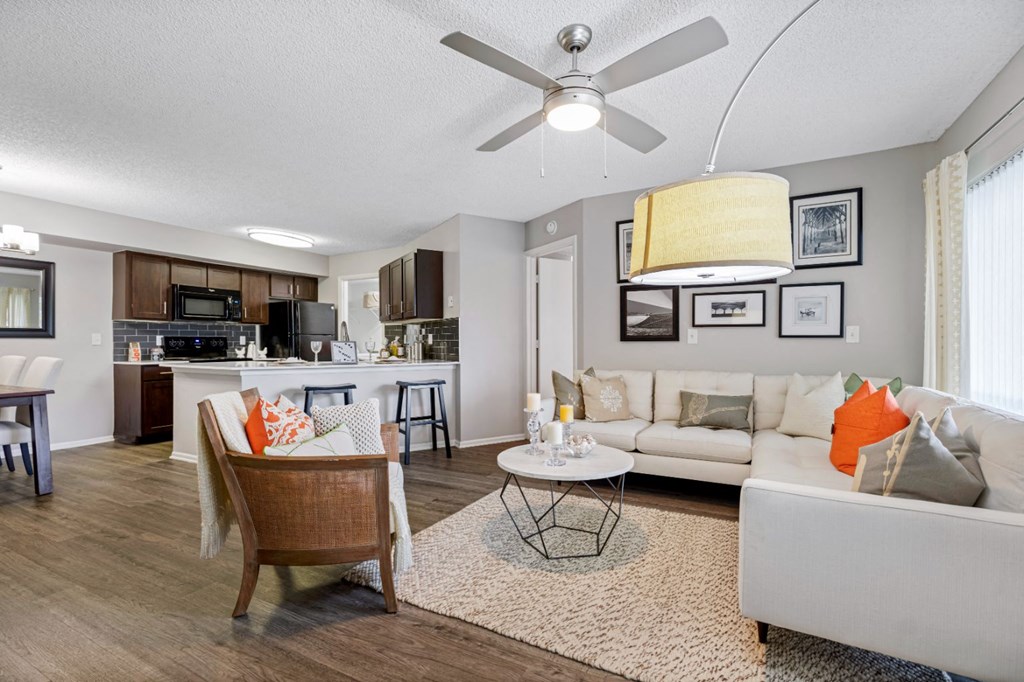 a living room and kitchen with a ceiling fan