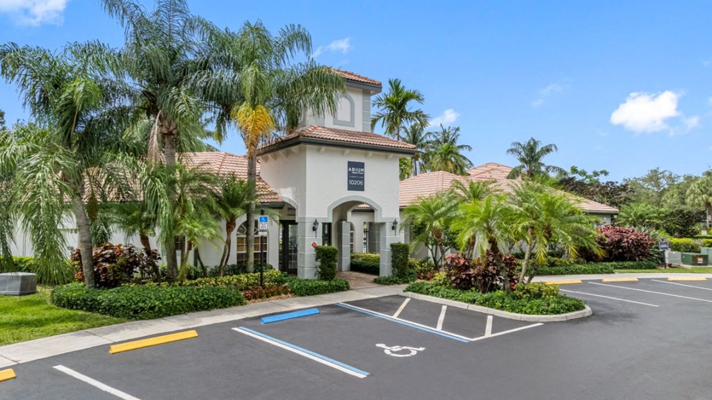 a villa with a parking lot and palm trees