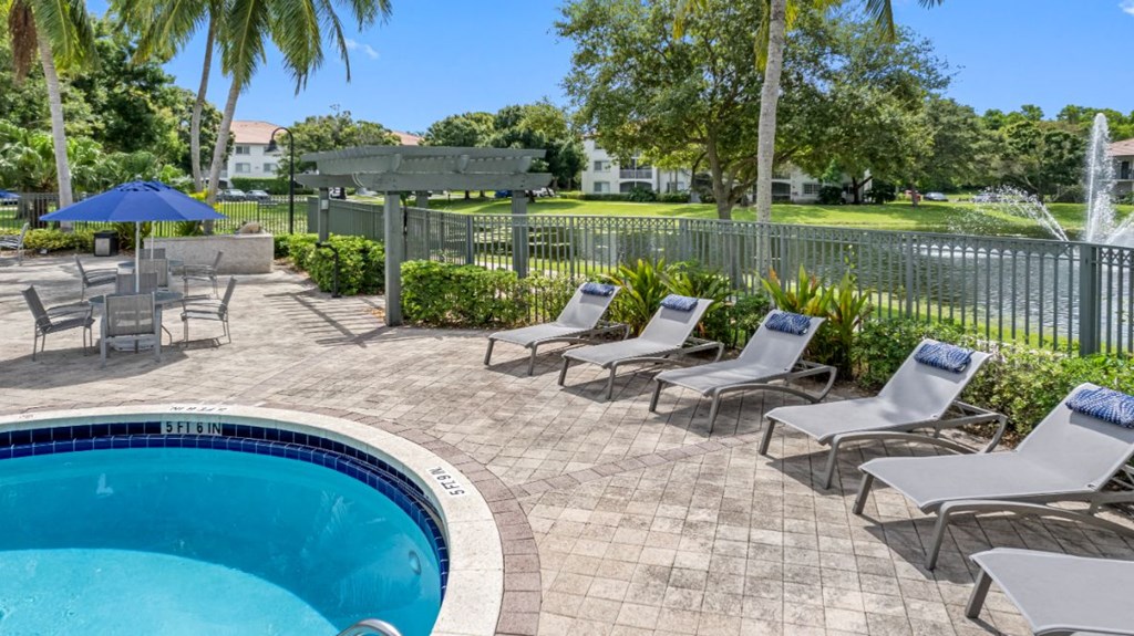 a swimming pool with lounge chairs and a poolside umbrella