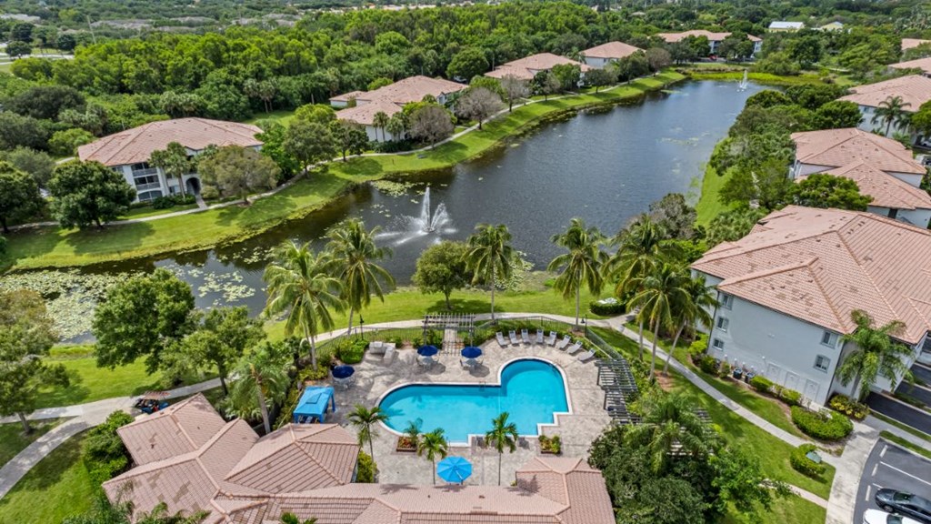 an aerial view of a house with a swimming pool and a lake