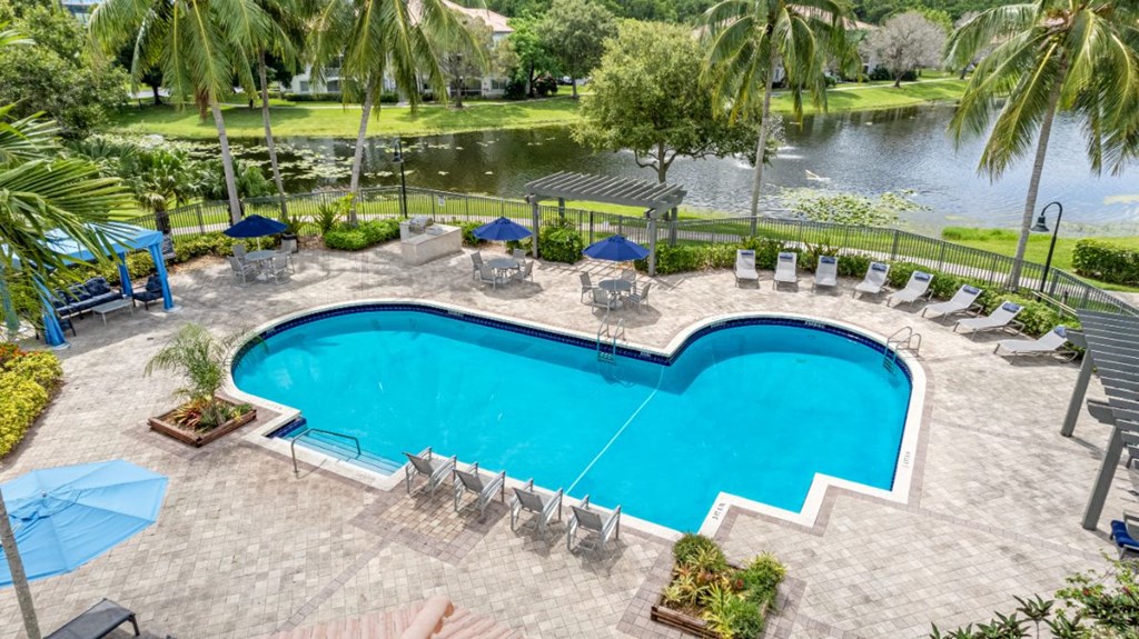 a large swimming pool with chairs and umbrellas