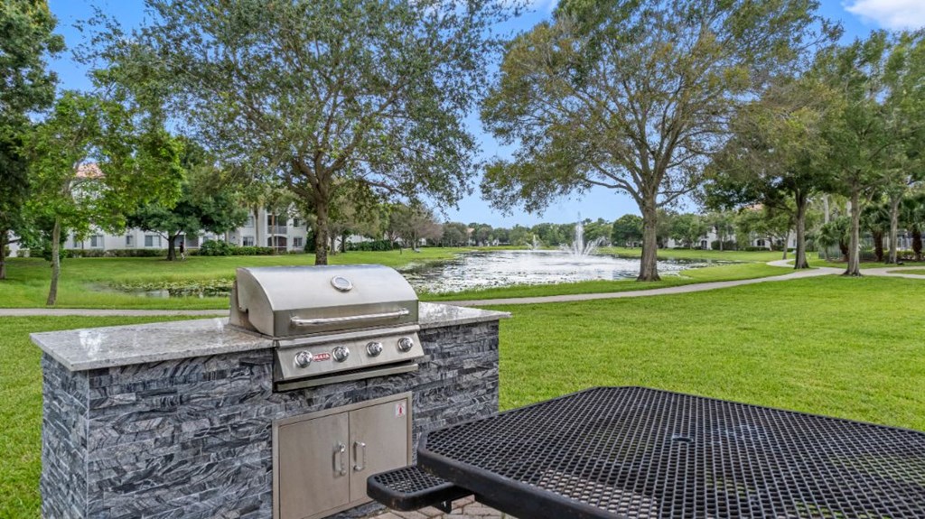 a grill and barbecue in a park next to a river