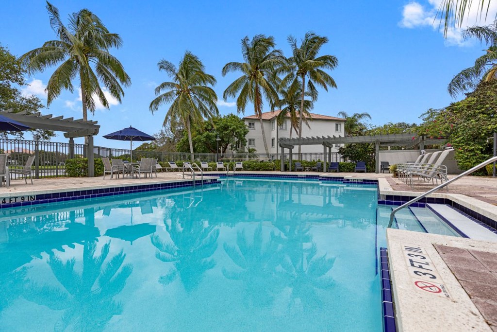 a swimming pool with palm trees in the background