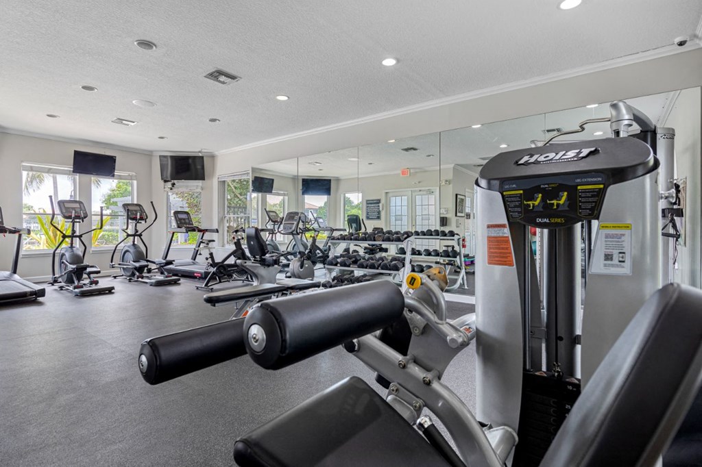 a gym with weights and cardio equipment on the floor and glass walls
