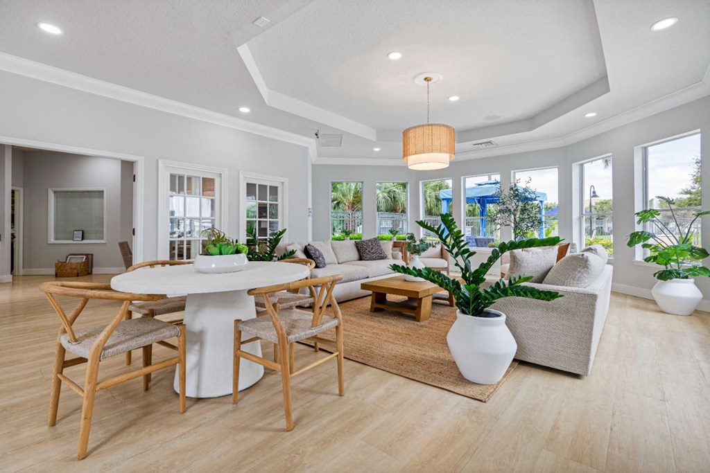 a living room with a table and chairs and a large window