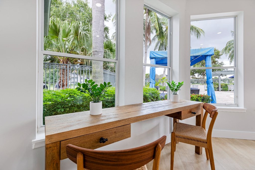 a home office with a large window and a desk with chairs