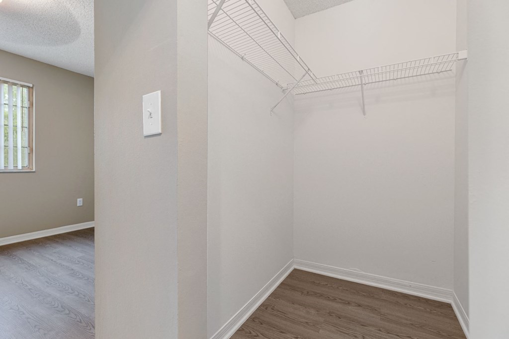 an empty room with a closet and a hard wood floor