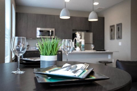 A modern dining room with a table set for two.